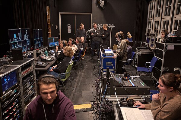Das Bild zeigt einen Einblick hinter die Kulissen. Studierende managen die Veranstaltung und der Rektor stattet ihnen einen Besuch ab. 