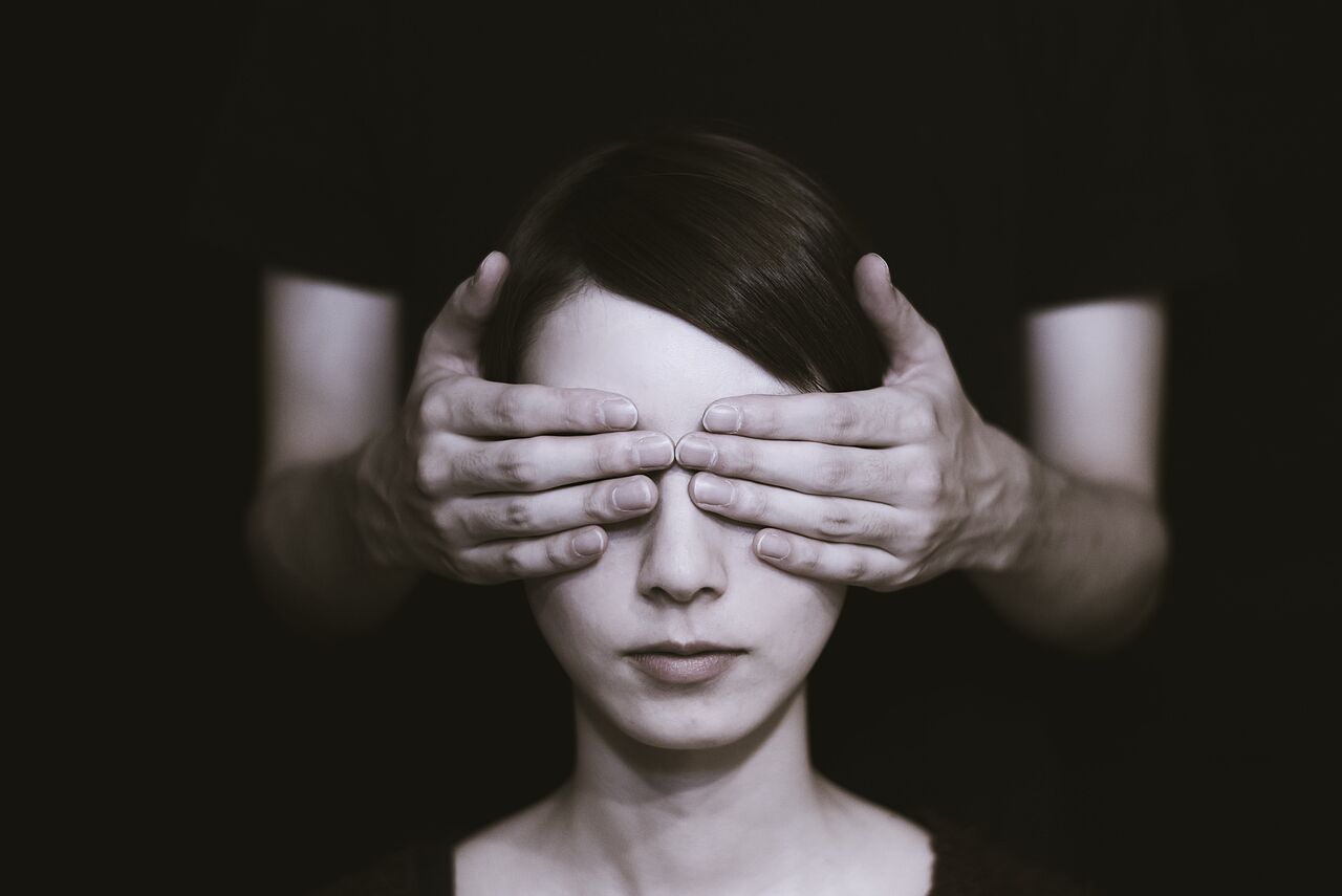 schwarz-weiß-Foto von einer Frau, deren Augen mit den Händen einer unbekannten Person bedeckt sind