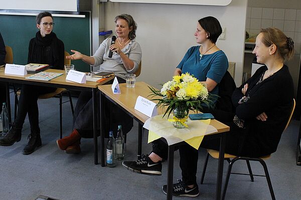 vier Frauen diskutieren auf einem Podium