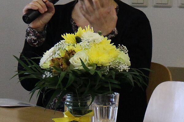 eine Frau mit Mikrophon spricht auf einem Podium 