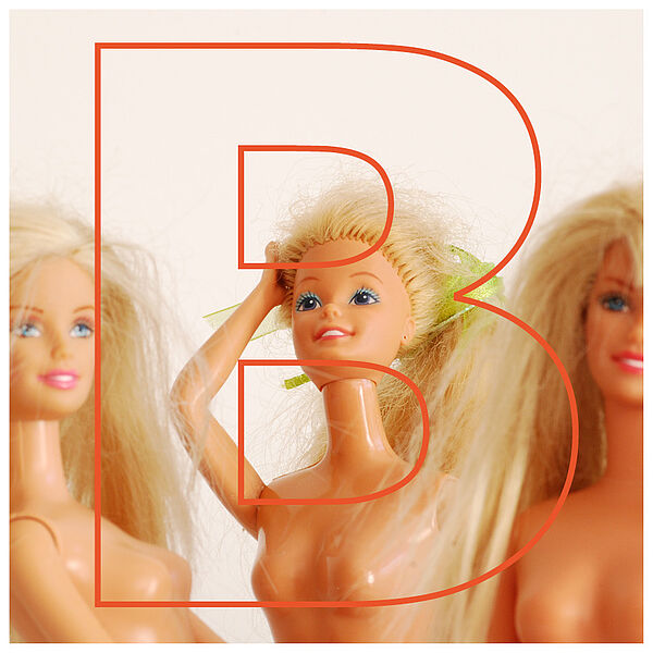 Drei Spielzeug-Puppen der Marke "Barbie" hinter dem Buchstaben "B" 
