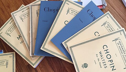 Mehrere Notensammlungen liegen fächerartig auf einem Tisch.