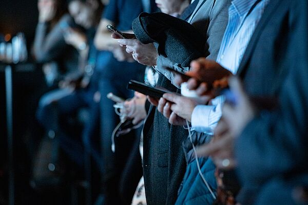 viele Hände die auf Smartphones drücken