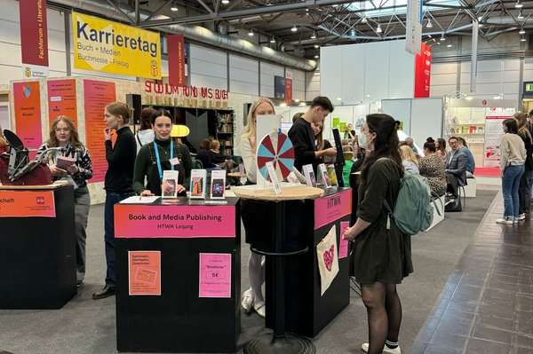 Menschen stehen an einem Messestand