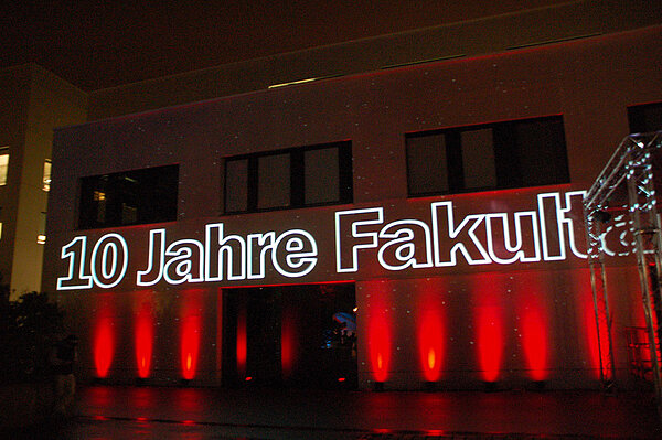 Projektion mit den Worten "10 Jahre Fakultät" auf dem Gebäude der Fakultät Medien