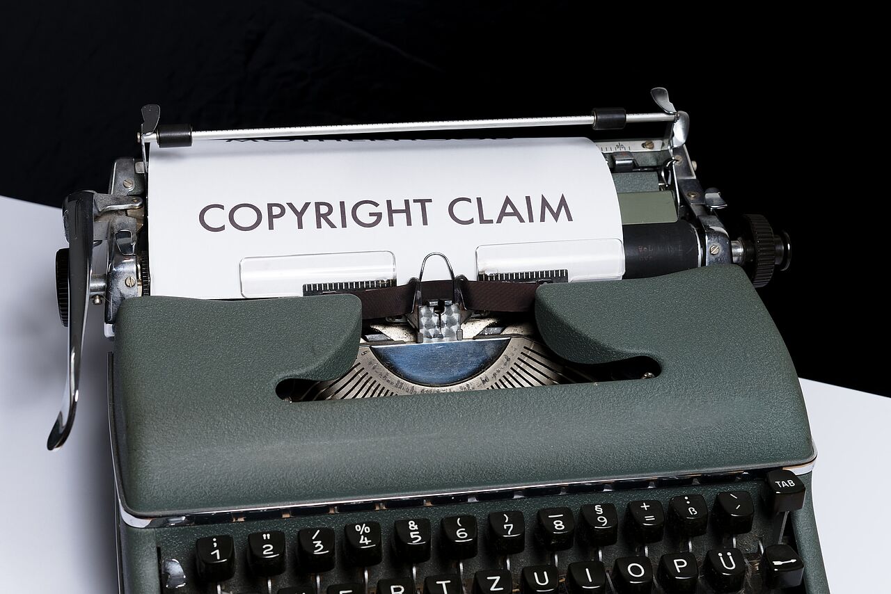 alte Schreibmaschine mit Papier, auf dem in Großbuchstaben "Copyright claim" steht 