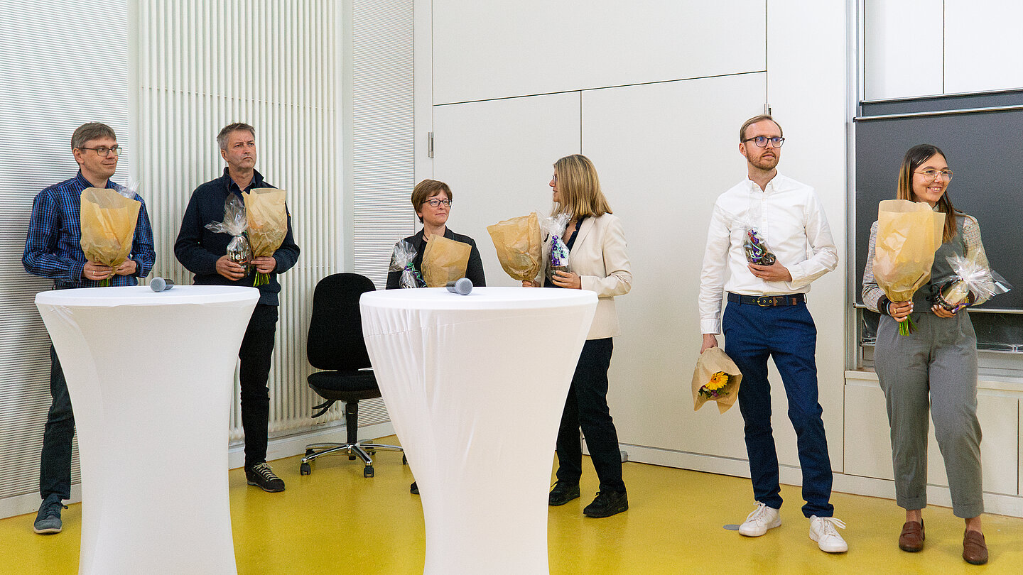 Gruppe von sechs Personen hinter Stehtischen