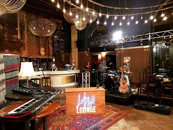 Die Kulisse der Late Night Lounge: zu sehen sind die Instrumente der Band, der Moderationstisch, die Bar
