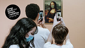 Drei Jugendliche stehen vor dem Bild der Mona Lisa und machen ein Foto mit ihrem Smartphone
