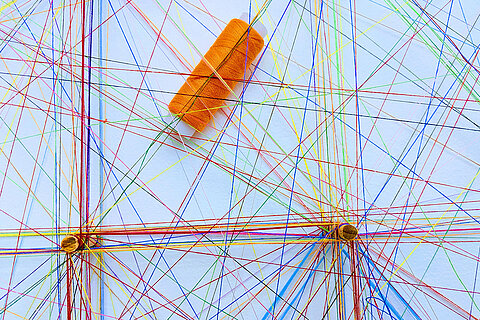 Saxony High Five: Cluster für medialen Wissens- und Technologietransfer weiße Pinnwand mit verschiedenen farbigen Bindfäden und einer orangenen Garnrolle