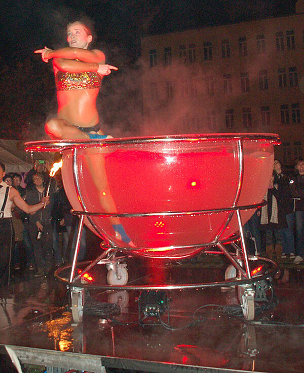 Artistin an einem rot angeleuchteten Wasserbecken