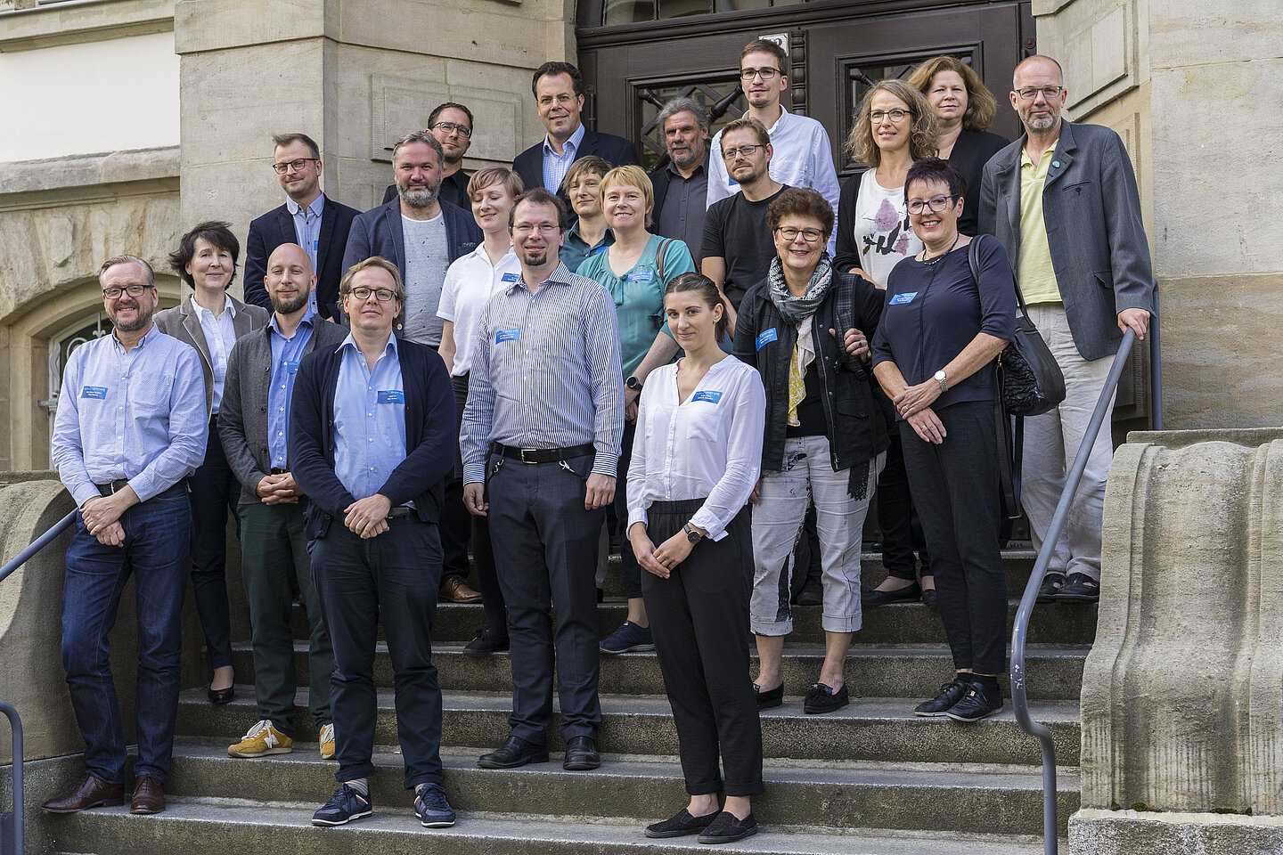 Rund 20 Workshop-Teilnehmer stehen auf der Treppe vor einem HTWK-Gebäude