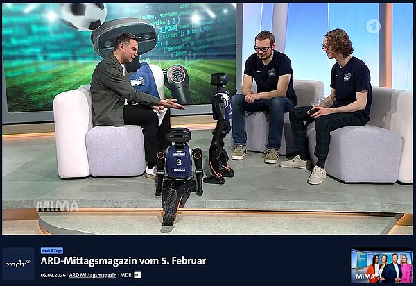 Im Fernsehstudio interagiert Moderator Tino Böttcher sichtlich begeistert mit einem der beiden HTWK Roboten im Gespräch mit Felix Loos und Johannes Walter. 