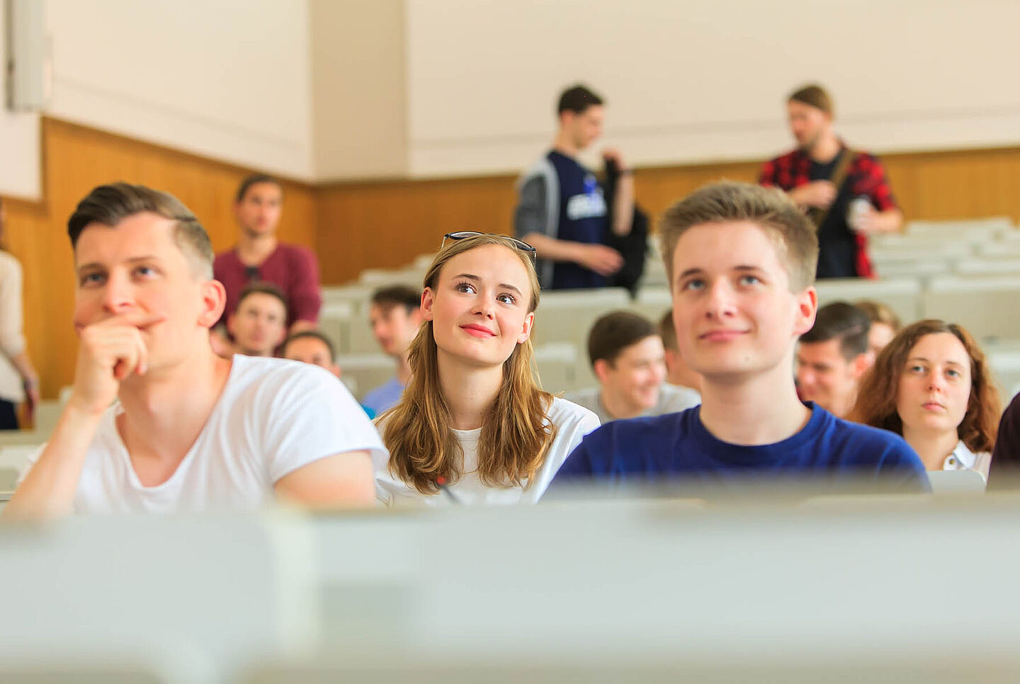 Mehrere Studierende sitzen in den Reihen eines Hörsaals.