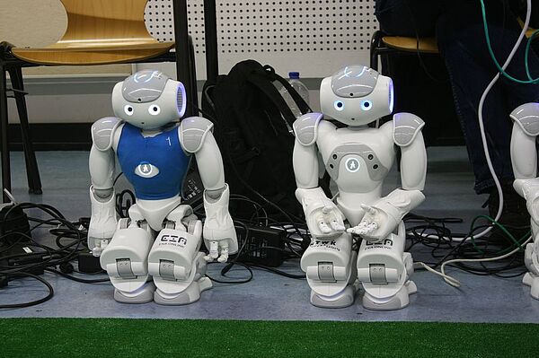 Zwei Roboter stehen auf dem Boden