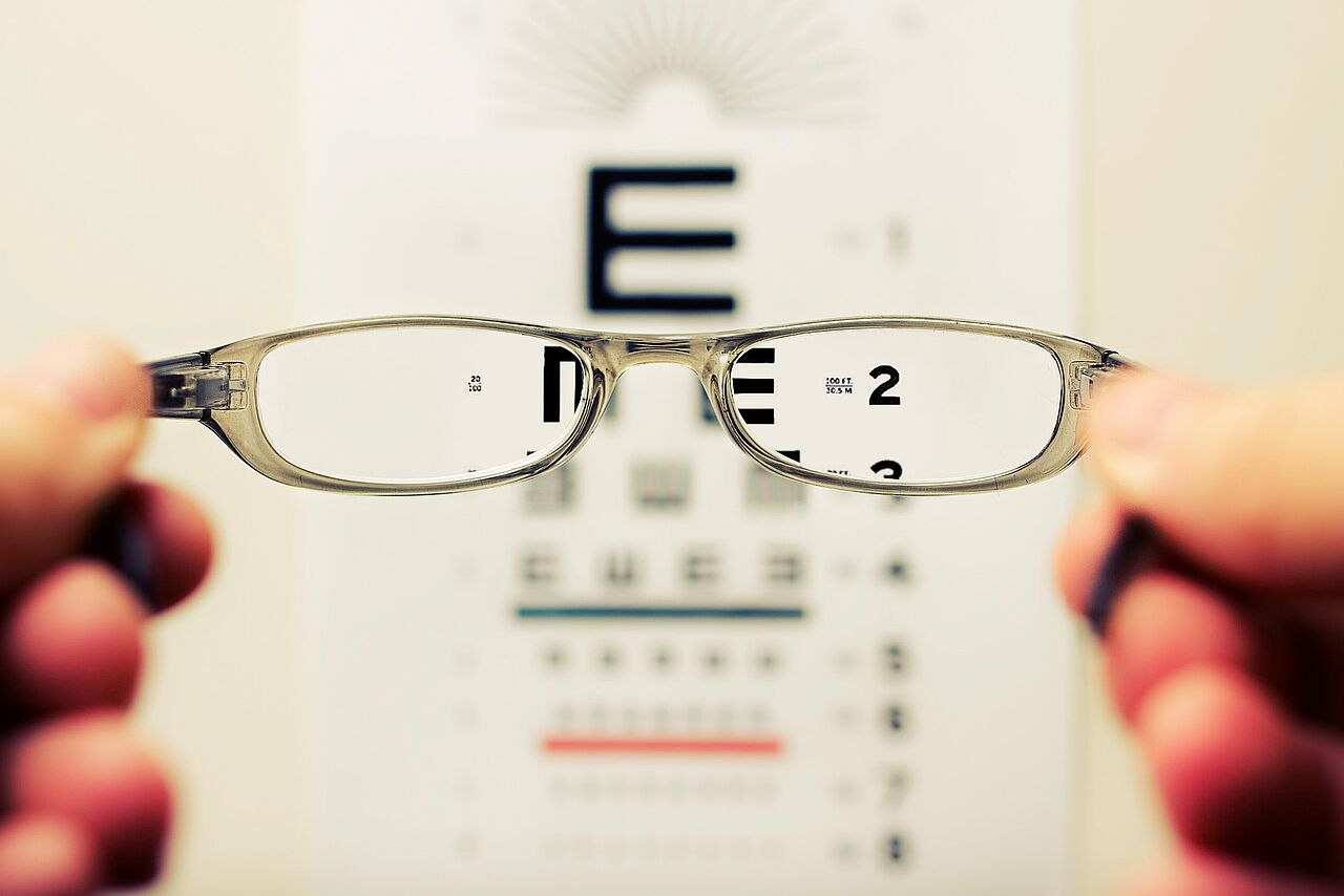 Blick aus Sicht einer unbekannten Person durch eine Brille auf eine Sehprobentafel