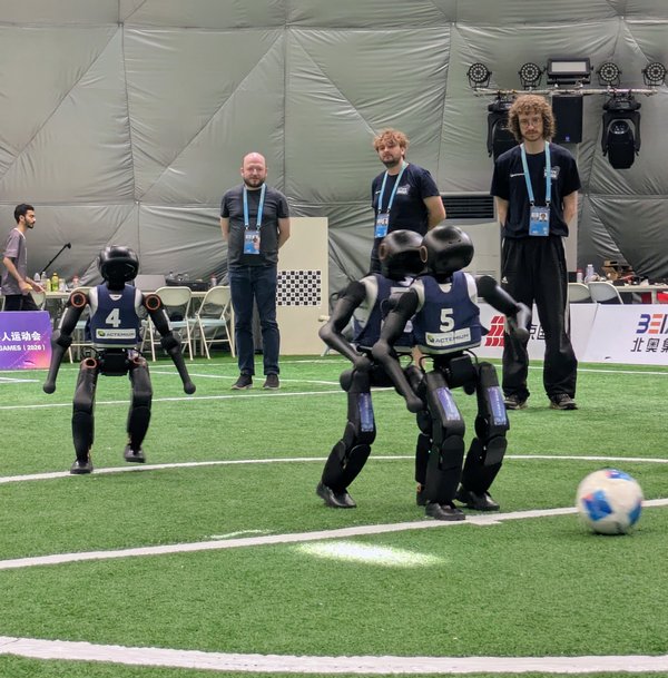 Humanoide Roboter spielen Fußball und Menschen schauen zu