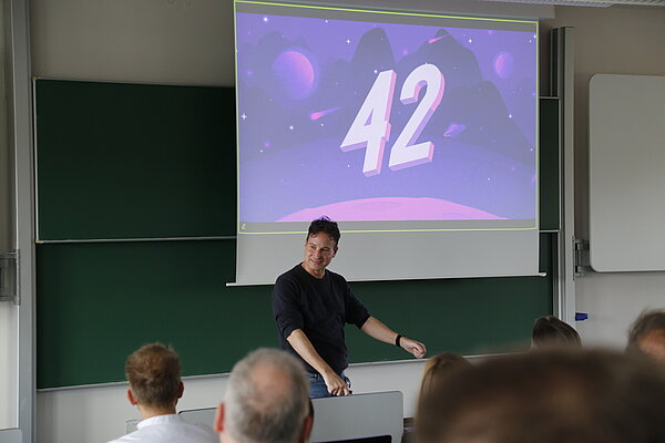 Redner vor Projektion in Hörsaal