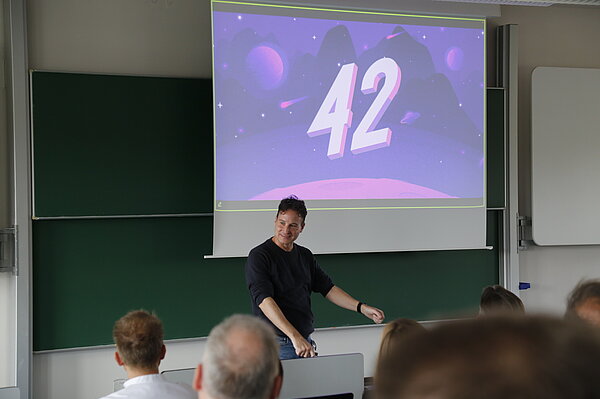 Redner vor Projektion in Hörsaal