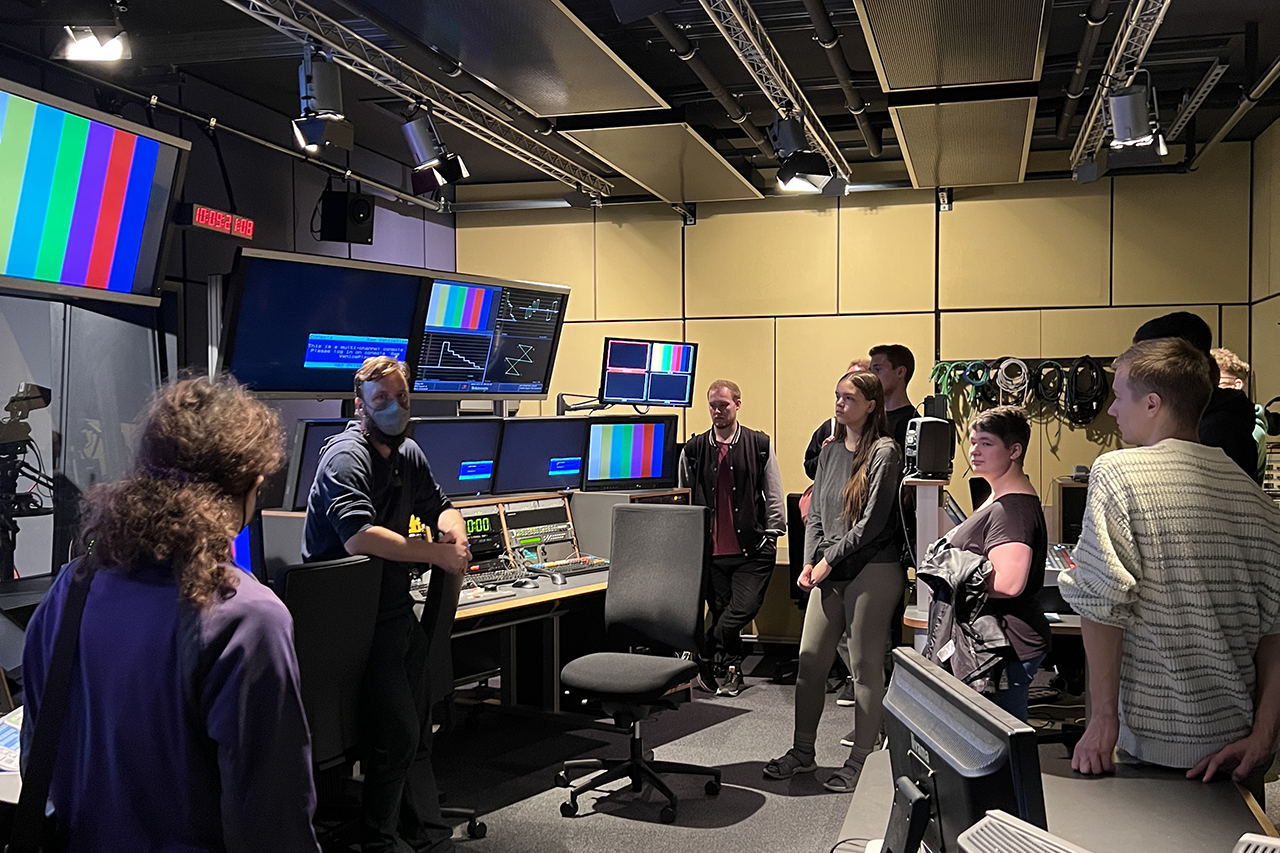 Teilnehmende im Medienraum mit viel Medientechnik