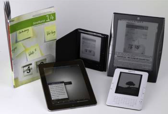Vier verschidene E-Book-Reader und ein Papierheft auf weißer Oberfläche