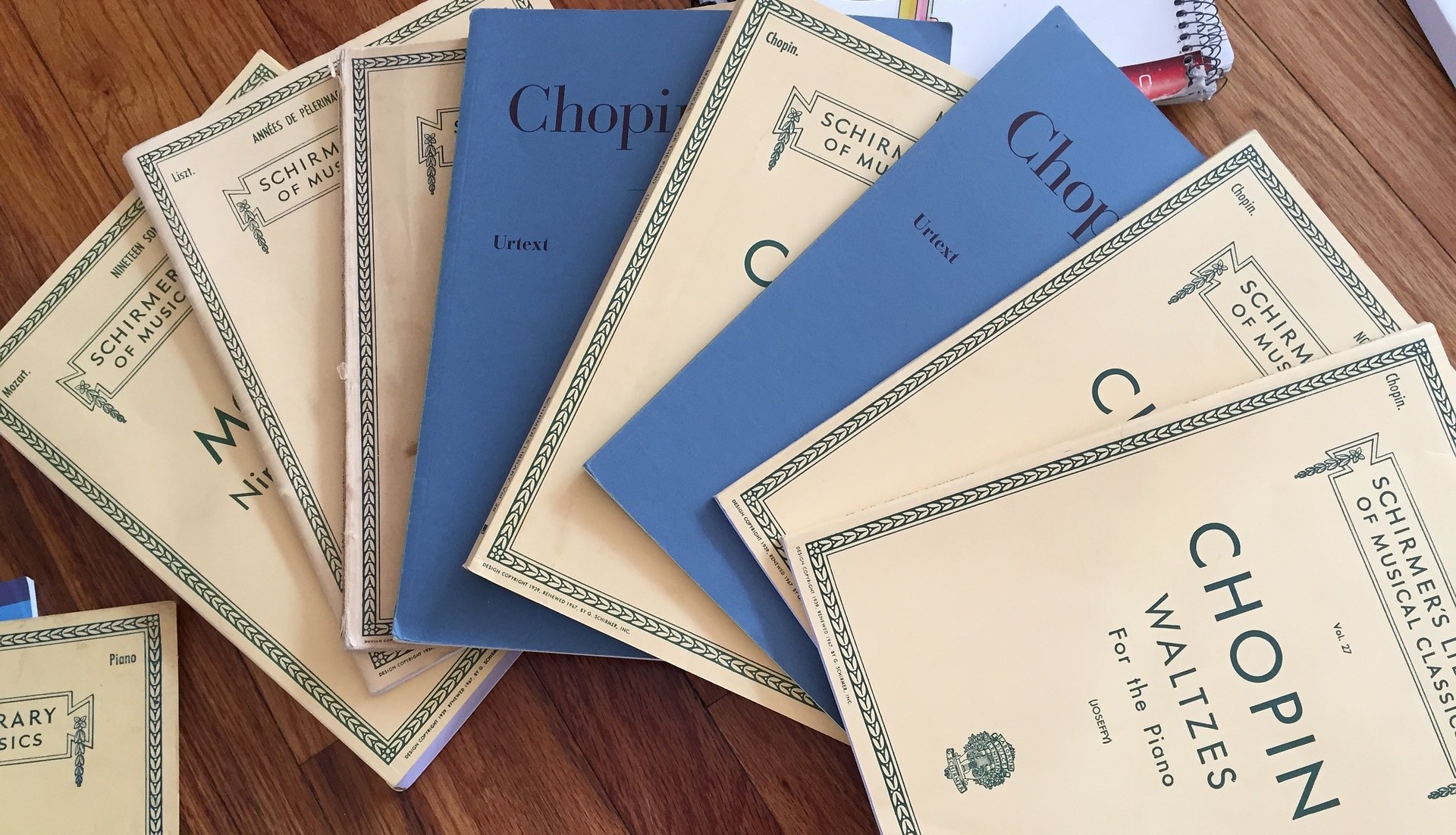 Mehrere Notensammlungen liegen fächerartig auf einem Tisch.