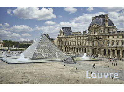 Blick auf den Louvre in Paris. Man sieht den Eingangsbereich des historischen Gebäudes sowie die gläserne Pyramide im Vordergrund.
