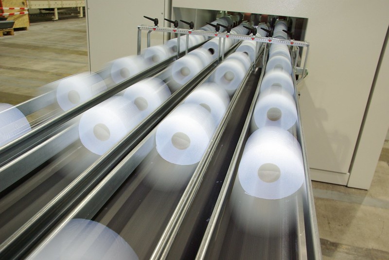 Logistik und Verteilung im Fokus: Engpässe sollen künftig der Vergangenheit angehören – mit maßgeschneiderten Logistik-Konzepten und einer Anpassung der Abgabemenge (Ziel: Einzelblattverpackung). (Foto: SCA Deutschland) Produktionsstrecke von Toilettenpapier (viele Rollen auf Förderband)